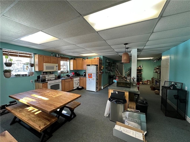 dining area featuring dark carpet and a drop ceiling