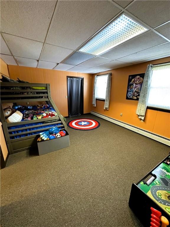 game room featuring a paneled ceiling and a baseboard radiator