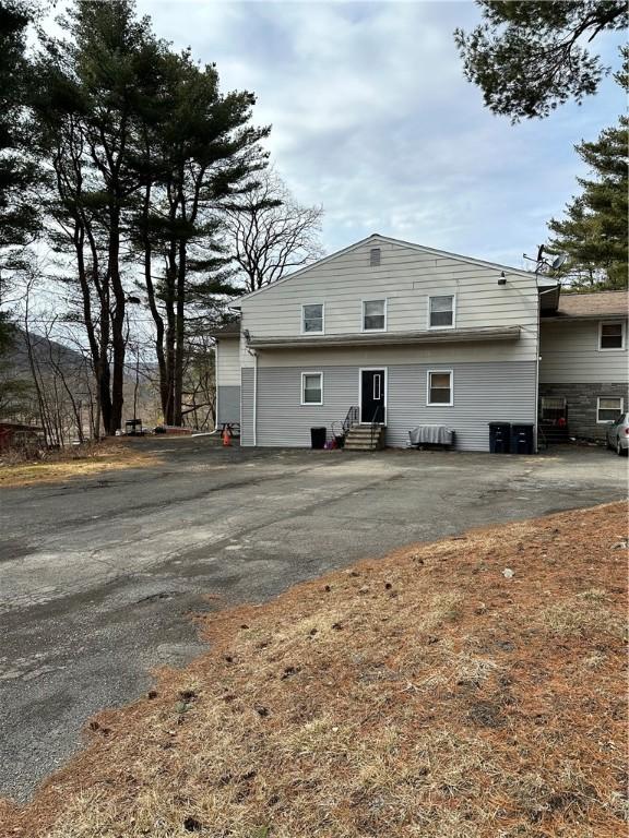 back of property with entry steps and driveway