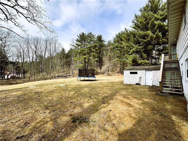 view of yard featuring an outdoor structure, stairs, a storage shed, and a trampoline