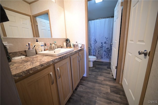 full bath featuring wood finished floors, vanity, toilet, and curtained shower