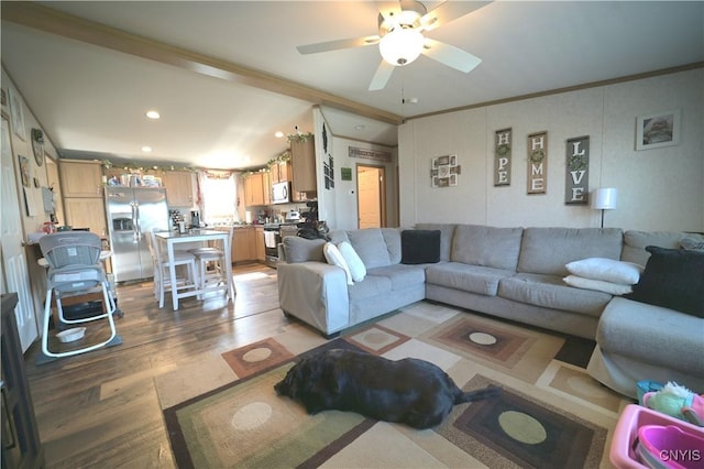 living area with recessed lighting, vaulted ceiling, ornamental molding, ceiling fan, and light wood finished floors