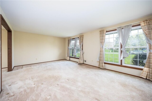 carpeted spare room featuring baseboards