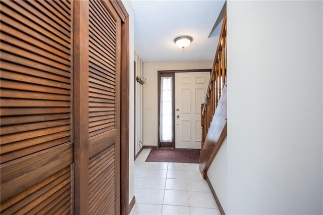 interior space with baseboards, light tile patterned floors, and stairs