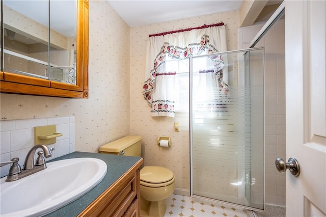 full bathroom featuring toilet, a stall shower, wallpapered walls, and vanity