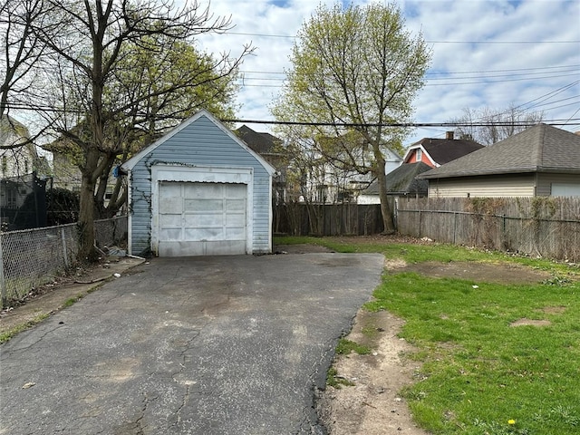 detached garage with fence and driveway