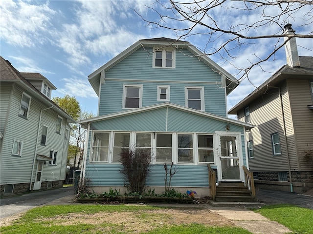 american foursquare style home with a sunroom and entry steps