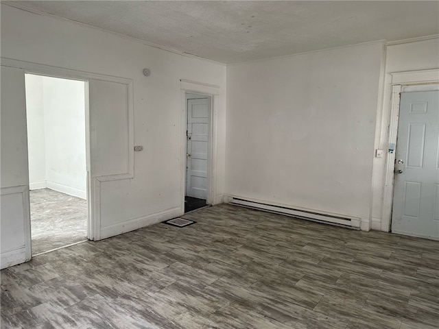 empty room with baseboard heating, visible vents, wood finished floors, and a textured ceiling
