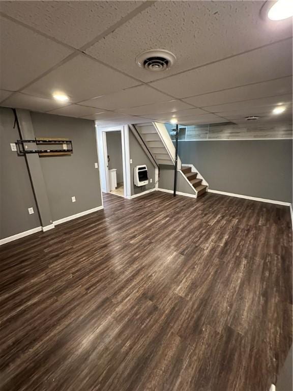 finished below grade area featuring visible vents, stairway, wood finished floors, and baseboards