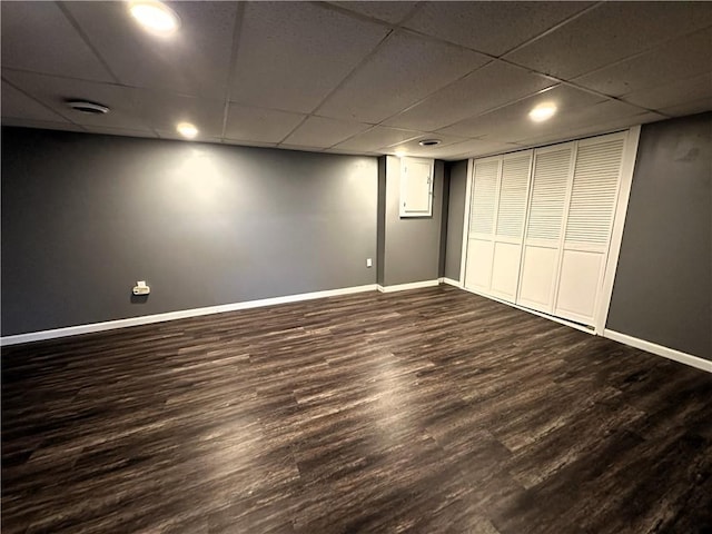 unfurnished bedroom featuring dark wood-type flooring, recessed lighting, a paneled ceiling, and baseboards