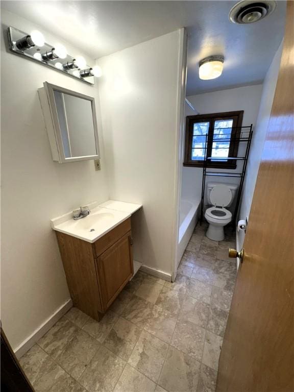bathroom featuring vanity, toilet, visible vents, and baseboards