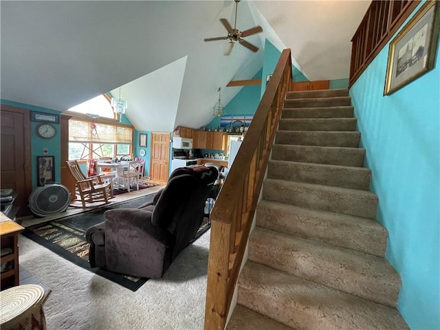 stairs with carpet, ceiling fan, and vaulted ceiling
