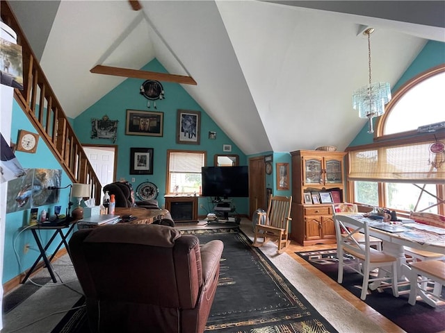 living room with an inviting chandelier, high vaulted ceiling, and stairs
