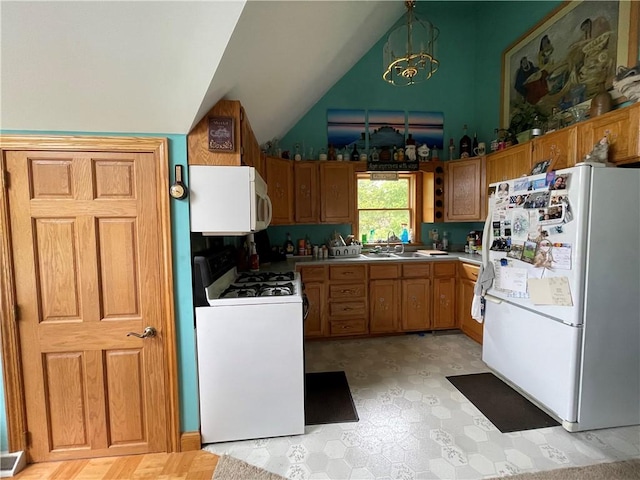 kitchen featuring lofted ceiling, a sink, white appliances, a notable chandelier, and brown cabinetry