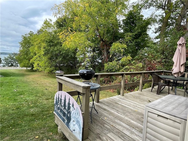 wooden deck with outdoor dining space and a lawn