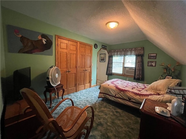 bedroom featuring lofted ceiling, a textured ceiling, a closet, and carpet flooring