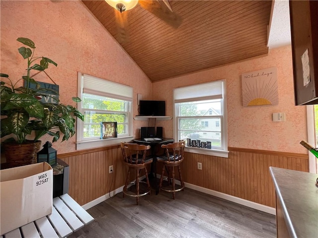 office area featuring wooden ceiling, wood finished floors, vaulted ceiling, a wainscoted wall, and wooden walls