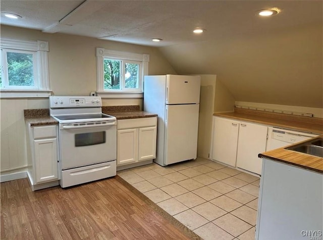 kitchen featuring white cabinets, a wealth of natural light, lofted ceiling, and white appliances