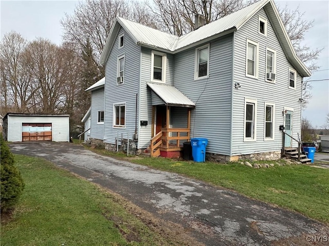 traditional-style house with an outdoor structure, metal roof, a front yard, and entry steps