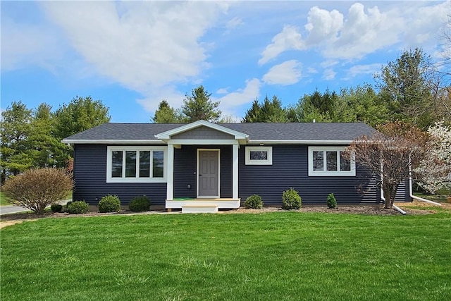 ranch-style house featuring a shingled roof and a front lawn