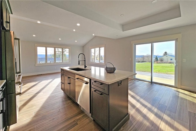 kitchen with wood finished floors, light countertops, dishwasher, a sink, and baseboards