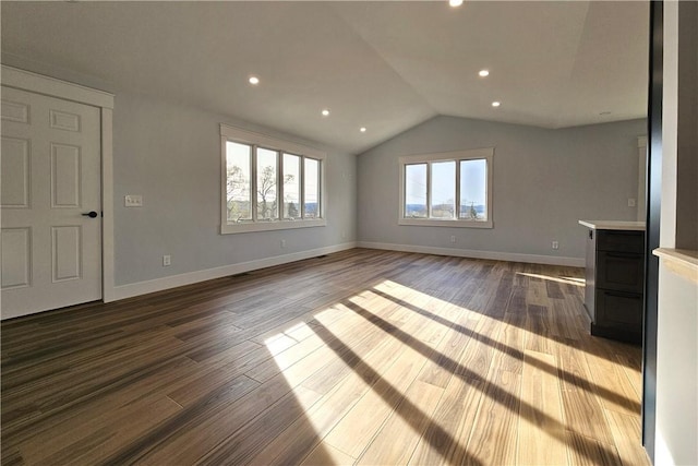 unfurnished living room with recessed lighting, dark wood-style flooring, lofted ceiling, and baseboards