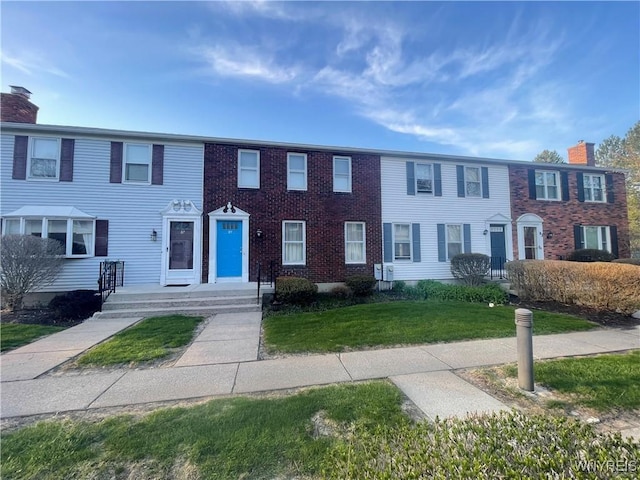 multi unit property with a front yard and a chimney