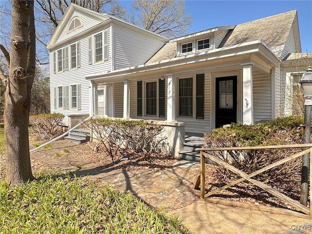 view of front of house featuring covered porch and a shingled roof