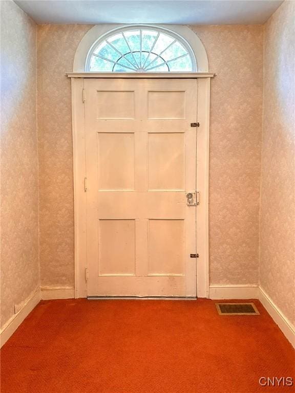 doorway with visible vents, plenty of natural light, and carpet flooring