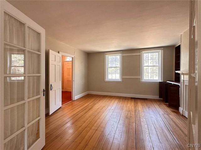 interior space with baseboards and light wood-type flooring