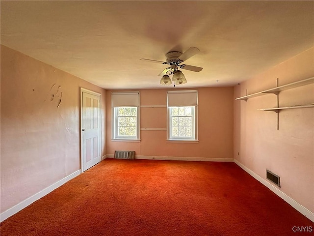 carpeted empty room with baseboards, visible vents, and ceiling fan