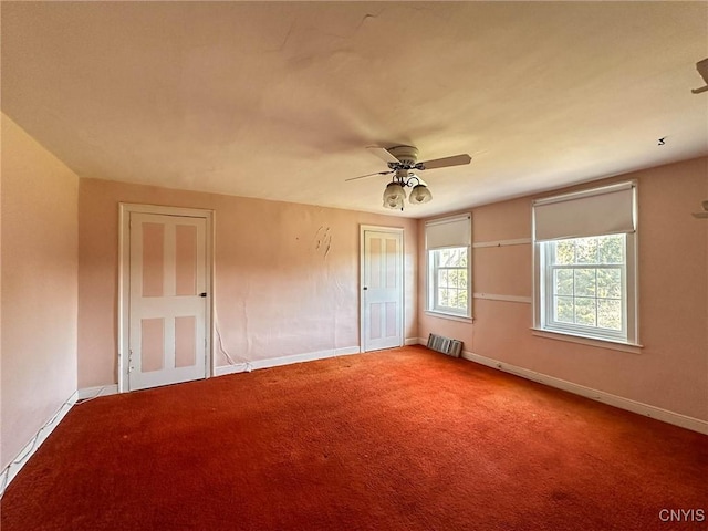carpeted spare room with radiator, ceiling fan, and baseboards