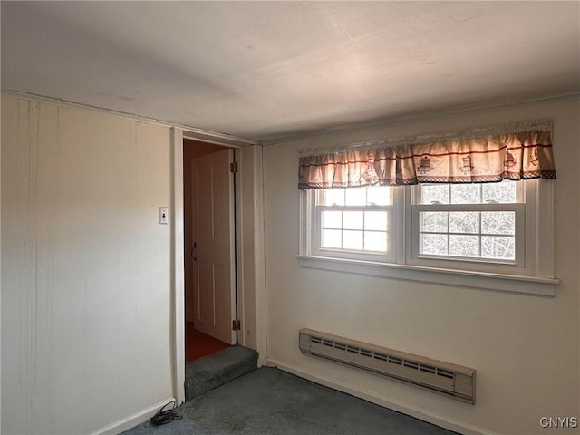 carpeted spare room featuring baseboards and a baseboard radiator