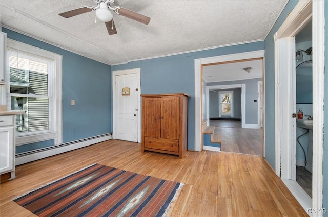 52 Front St, Norwich-City, NY 13815 - entrance foyer with light wood finished floors, a ceiling fan, baseboard heating, and a textured ceiling