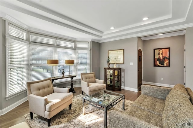 interior space with baseboards, a tray ceiling, and arched walkways