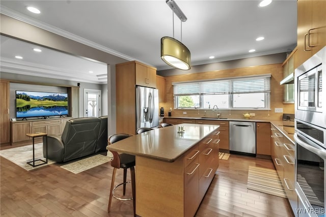kitchen featuring recessed lighting, a sink, light wood-type flooring, crown molding, and appliances with stainless steel finishes