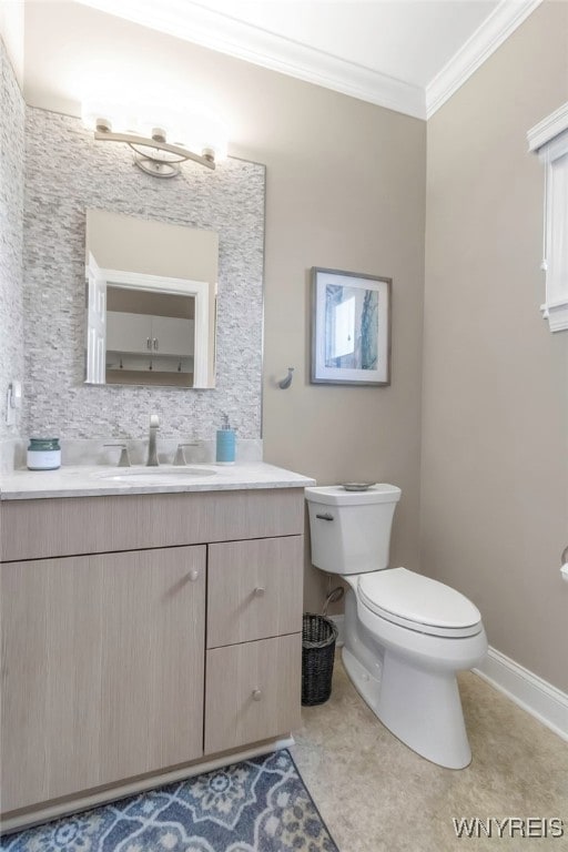 bathroom with crown molding, toilet, vanity, and baseboards