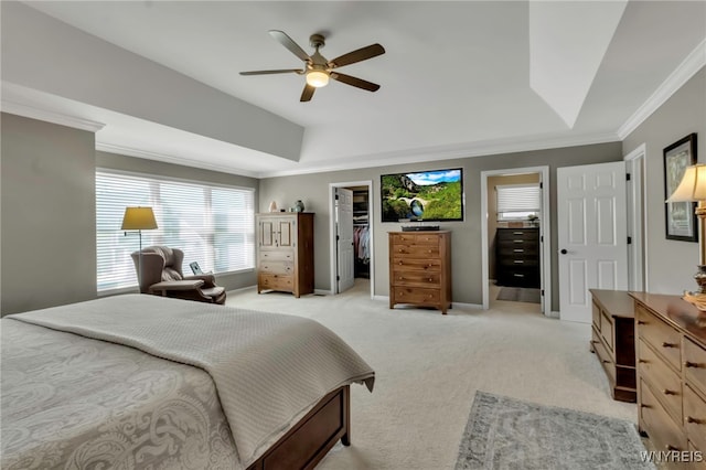 bedroom with crown molding, a ceiling fan, a walk in closet, light carpet, and baseboards