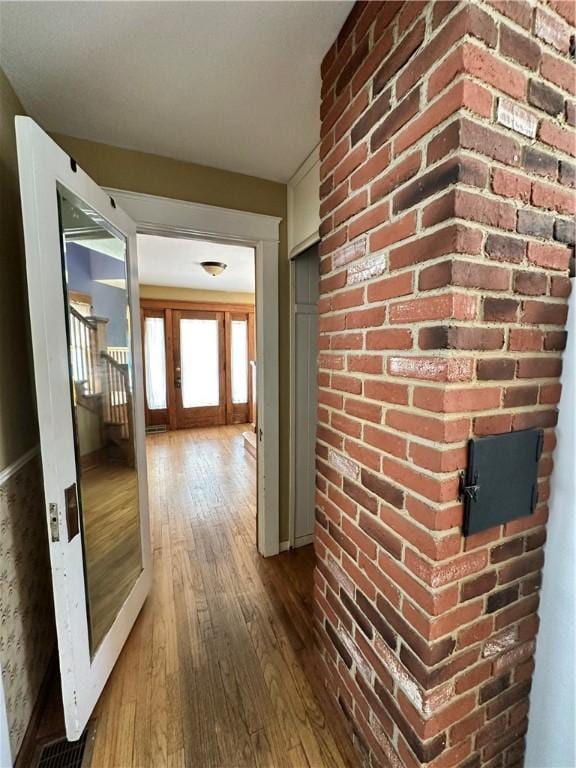 hallway featuring baseboards and hardwood / wood-style flooring