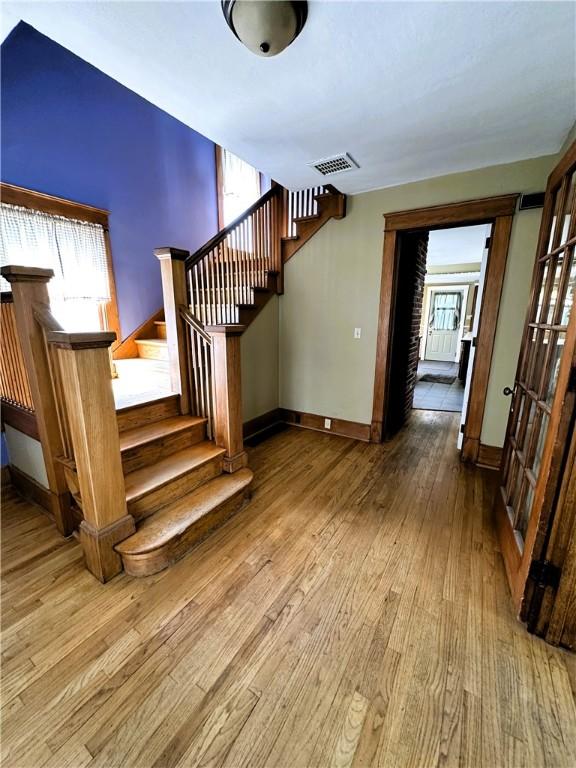 stairs featuring visible vents, hardwood / wood-style floors, and baseboards