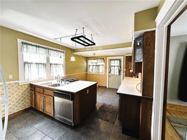 kitchen featuring a wainscoted wall, a sink, dishwasher, and light countertops
