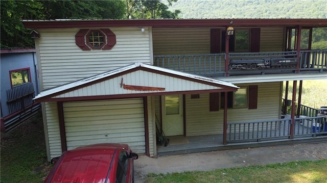 view of front of house featuring a porch, a garage, and a balcony