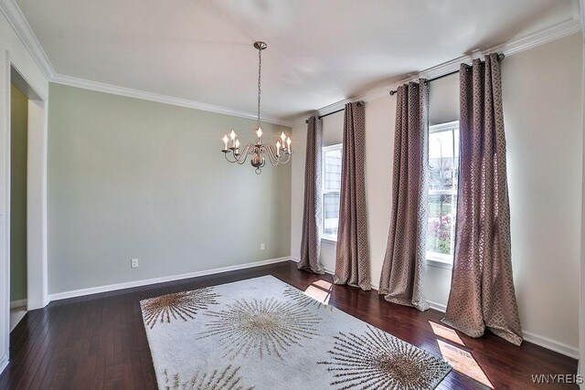 interior space featuring wood-type flooring, baseboards, a chandelier, and ornamental molding