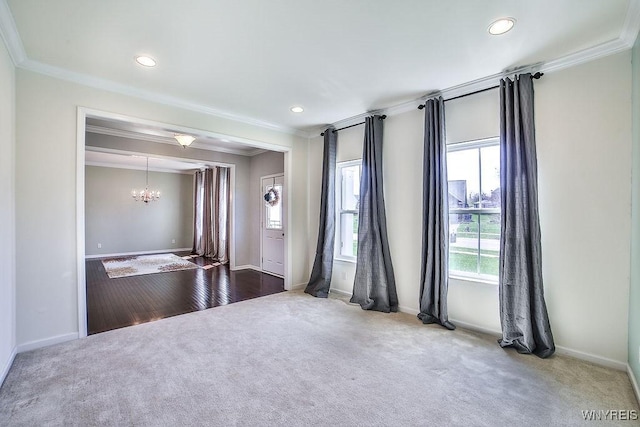 carpeted spare room featuring crown molding, baseboards, recessed lighting, and a chandelier