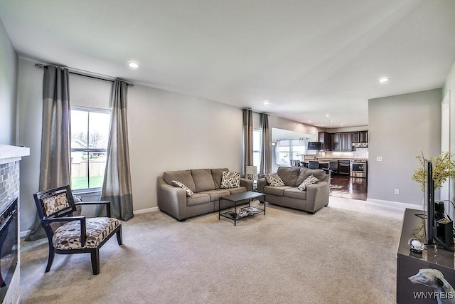 living room featuring baseboards, a brick fireplace, recessed lighting, and light colored carpet