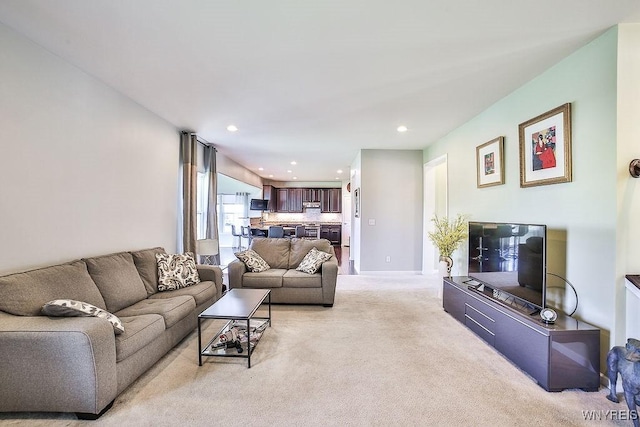 living area featuring light colored carpet, recessed lighting, and baseboards