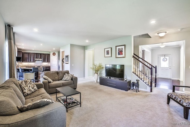 carpeted living room with crown molding, recessed lighting, baseboards, and stairway