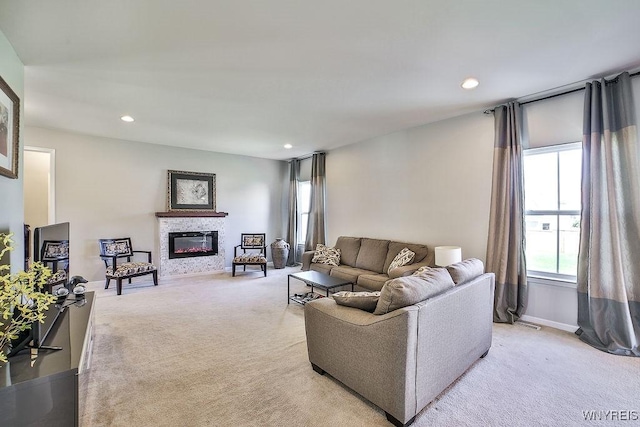 living room with light colored carpet, baseboards, a glass covered fireplace, and recessed lighting