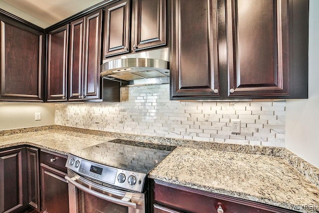 kitchen with under cabinet range hood, stainless steel range with electric cooktop, decorative backsplash, and dark brown cabinets