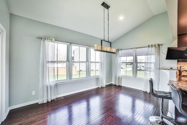 unfurnished dining area featuring baseboards, high vaulted ceiling, and hardwood / wood-style floors